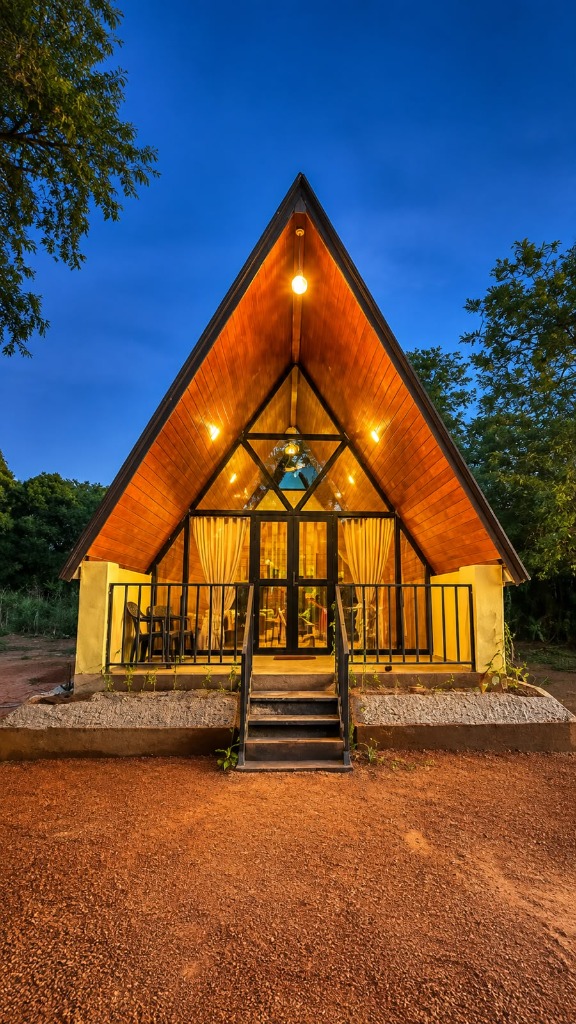 Green Heaven A-frame cabana at dusk with warm lights